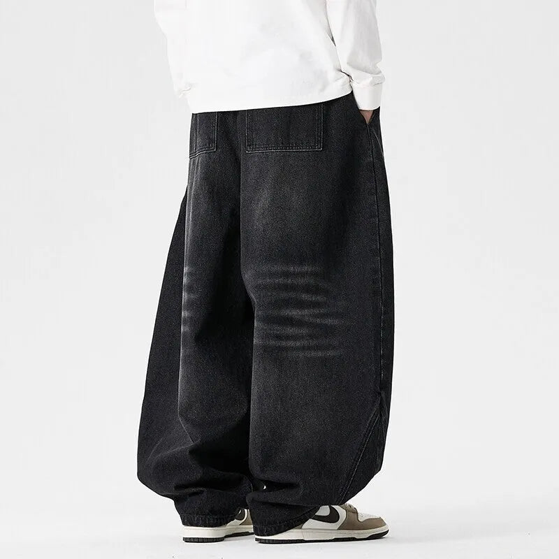 Men's loose-fit straight leg jeans in black denim on a hanger.