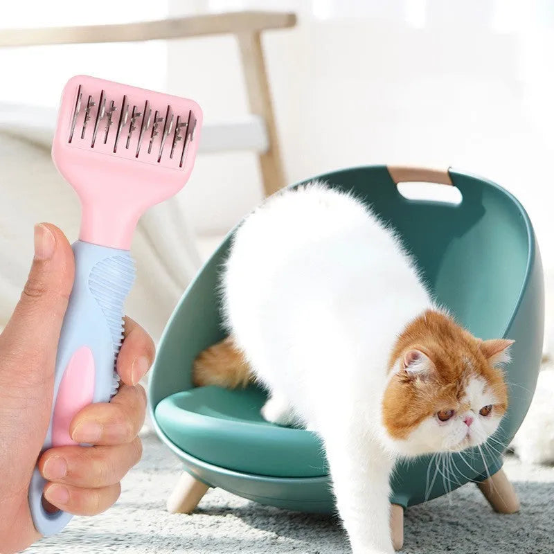 Pink dual-ended pet grooming brush with stainless steel knot knife and massage pins on a white background
