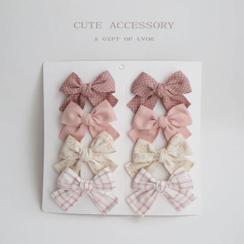 Set of children's fabric hairclips with dovetail bows in eight different colours and patterns.