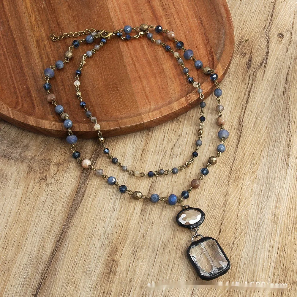 Tribal-style layered necklace with glass pendant and adjustable chain in beige or blue.