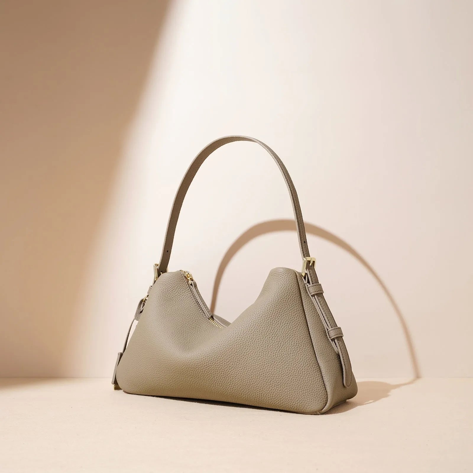 First layer cowhide leather pillow shape handbag in elephant gray with shoulder strap and open outer pocket