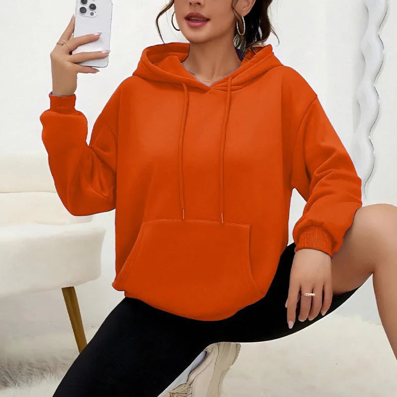 Women's loose grey drawstring hooded sweatshirt with side pockets, on a hanger.