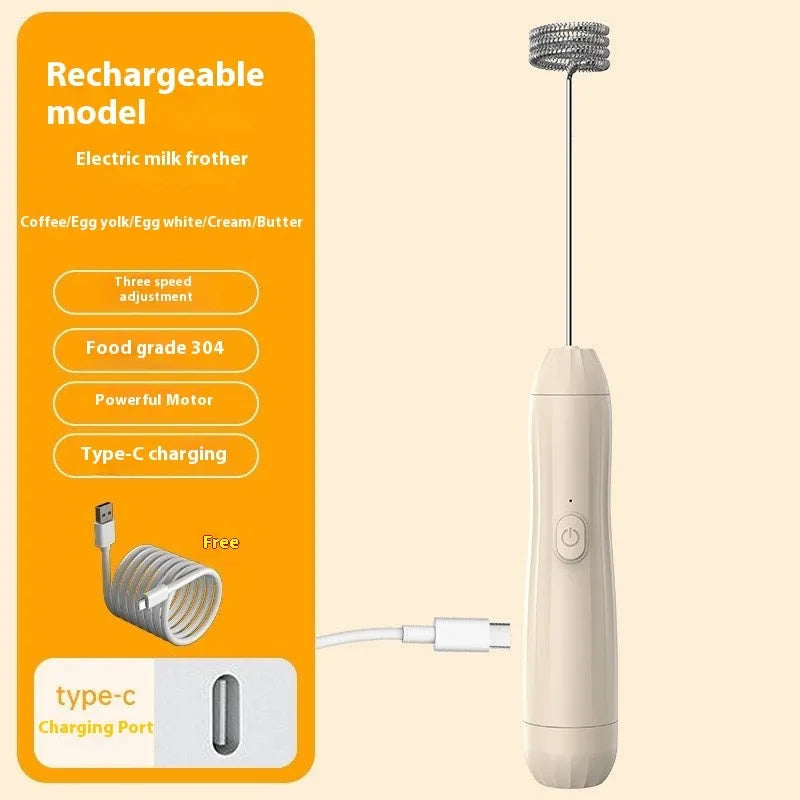 Compact black handheld milk frother with stainless steel whisk on a kitchen counter.