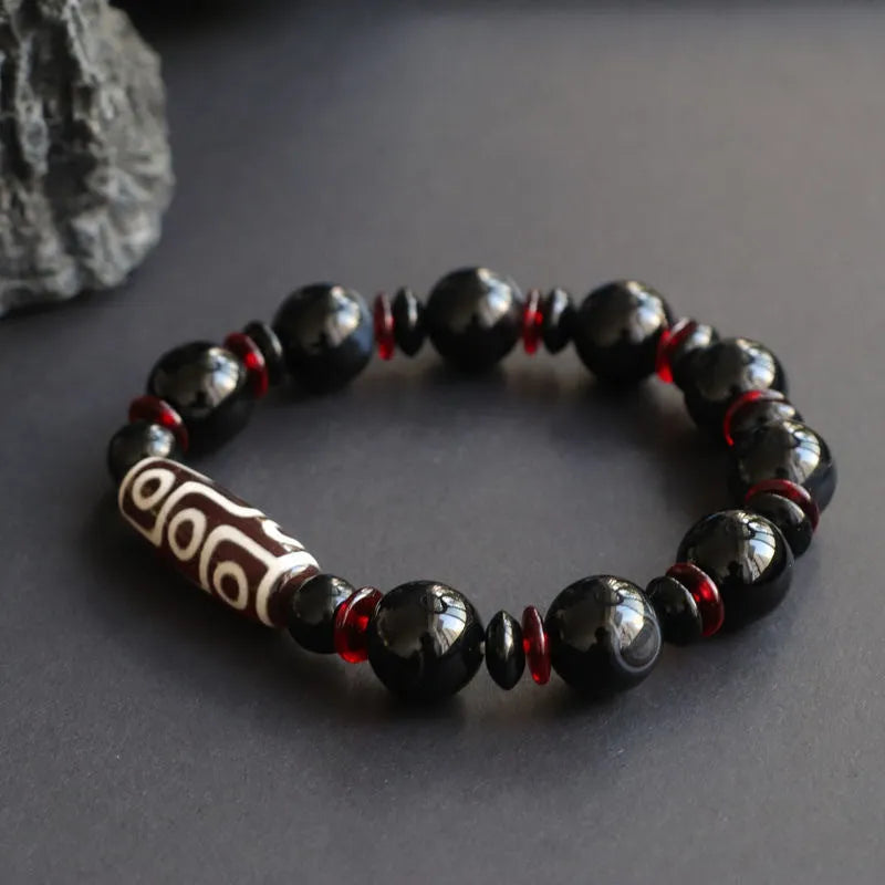 Black agate Dzi bead bracelet with hand-woven construction and geometry beads.