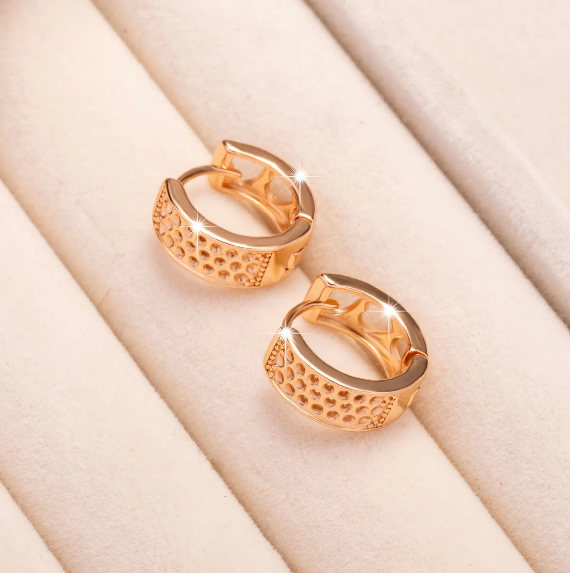 Rose gold heart-shaped women's earrings with three hollowed out sections in a circular design.