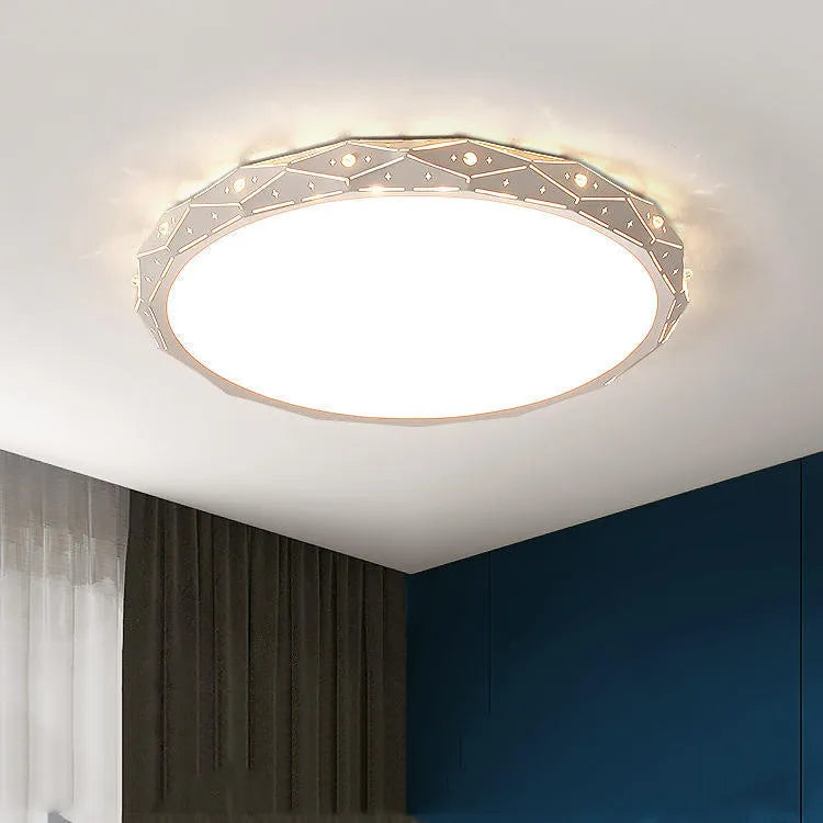 Round flush mount LED ceiling light with black iron frame on a white ceiling.