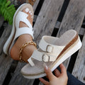 White wedge sandals with woven patent leather upper and open toe design on wooden surface