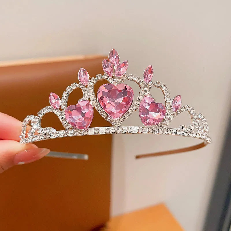 Children's electroplated alloy crown headband with pink crystals, shown on a model for scale.