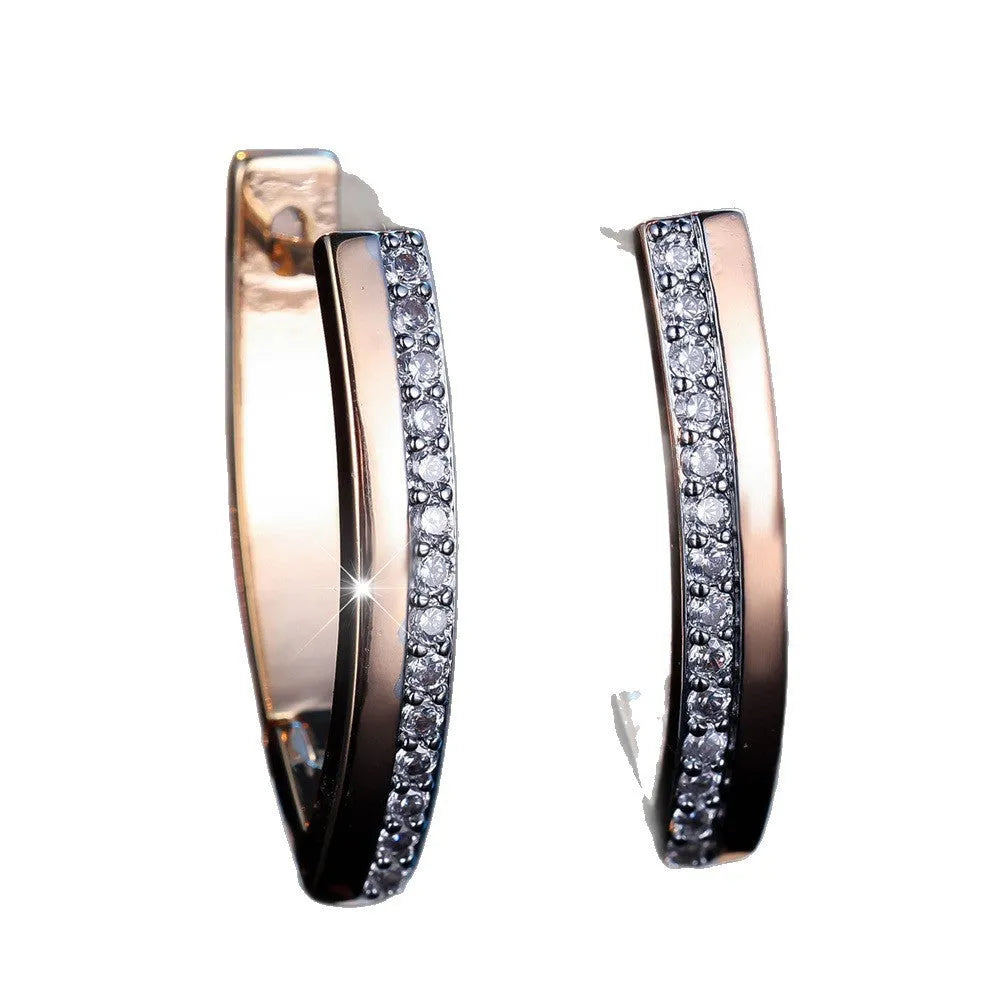 Geometric V-shaped women's earrings in champagne gold with white diamond accents on a copper base.