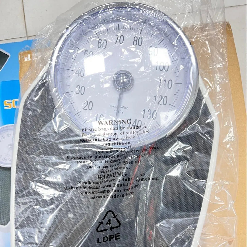 Black mechanical body weight scale with large dial on a simple platform