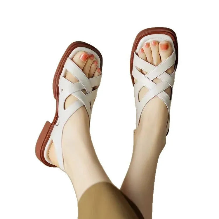 Women's glossy black patent leather beach sandals with square toe and cross-band strap.