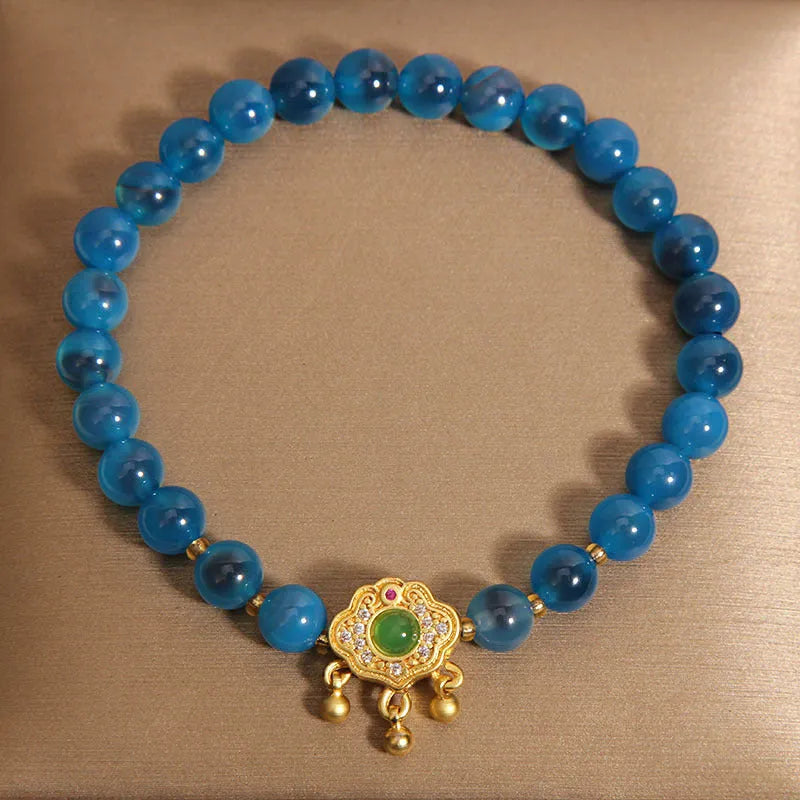 Blue agate safety lock pendant on a women's crystal bracelet with alloy-inlaid gemstones and rhinestones.