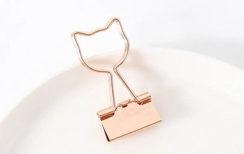 Gold-plated long tail hair clip showing decorative motifs including flamingo, love, clouds, cat, cactus, and bow designs