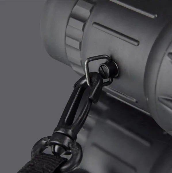 Black 16x52 monocular telescope showing eyepiece and objective lens, placed on a surface.