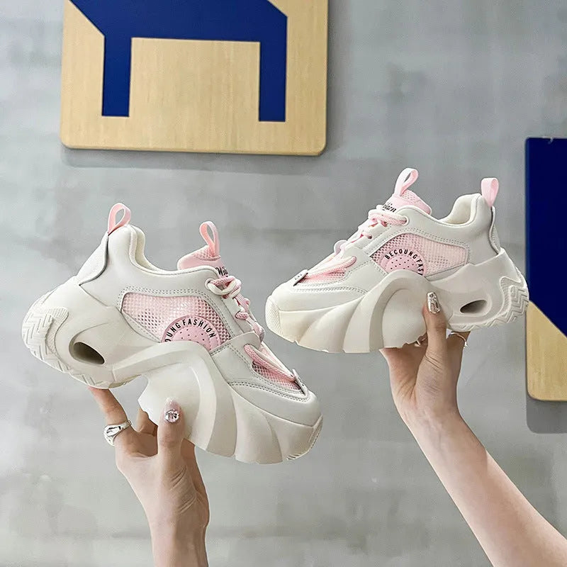 Women's beige sneakers with thick sole, cross straps, and mesh lining.