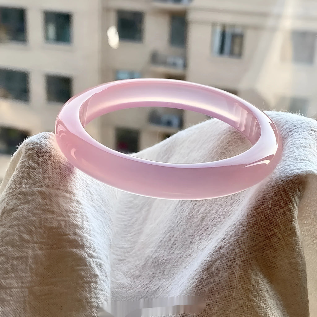 Natural agate wide tyre bead bracelet shown in a pink colour variant on a wrist.