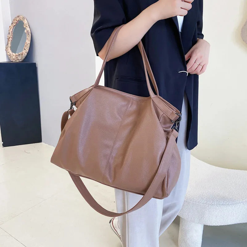 Large soft surface messenger bag showing horizontal square shape with adjustable shoulder strap and zip opening