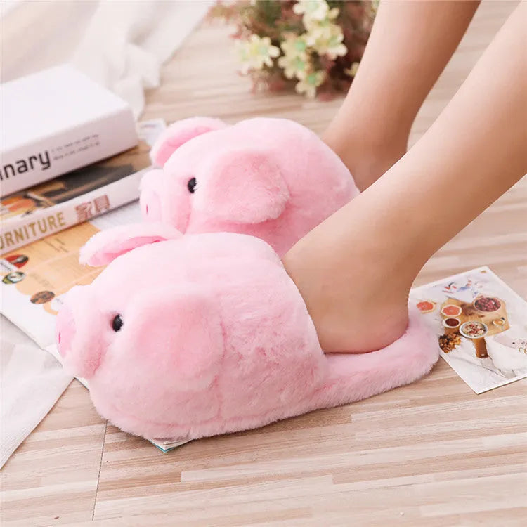 Pink pig-shaped floor slippers with short plush fabric on a plain background.