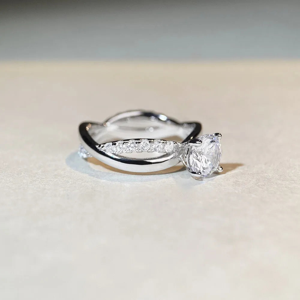 Silver ring with twisted arm design and a 1 karat moissanite stone in a four-claw setting.