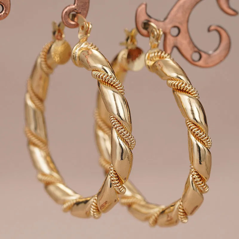 Geometric golden copper earrings with ear clip fastening showing ring and line design elements