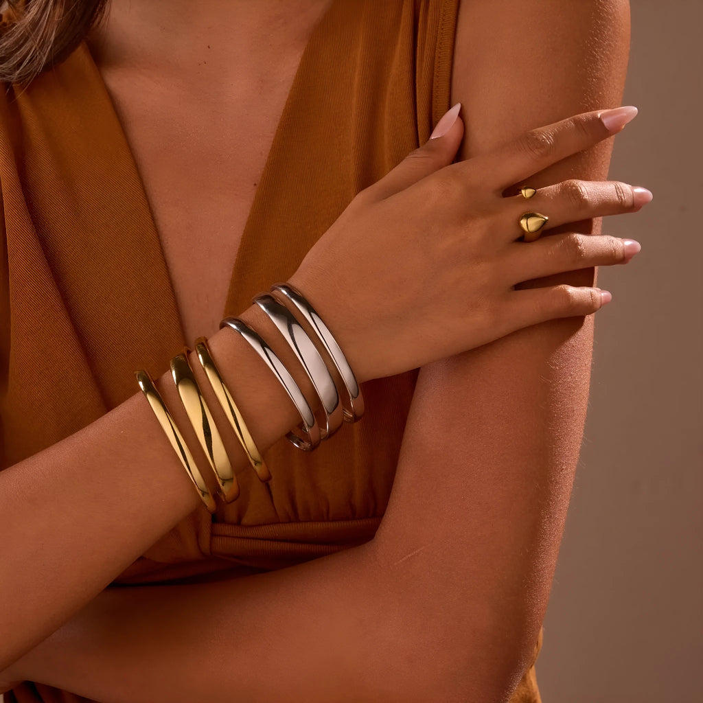 Stainless steel women's bracelet with geometric line design, shown in gold and steel finish options