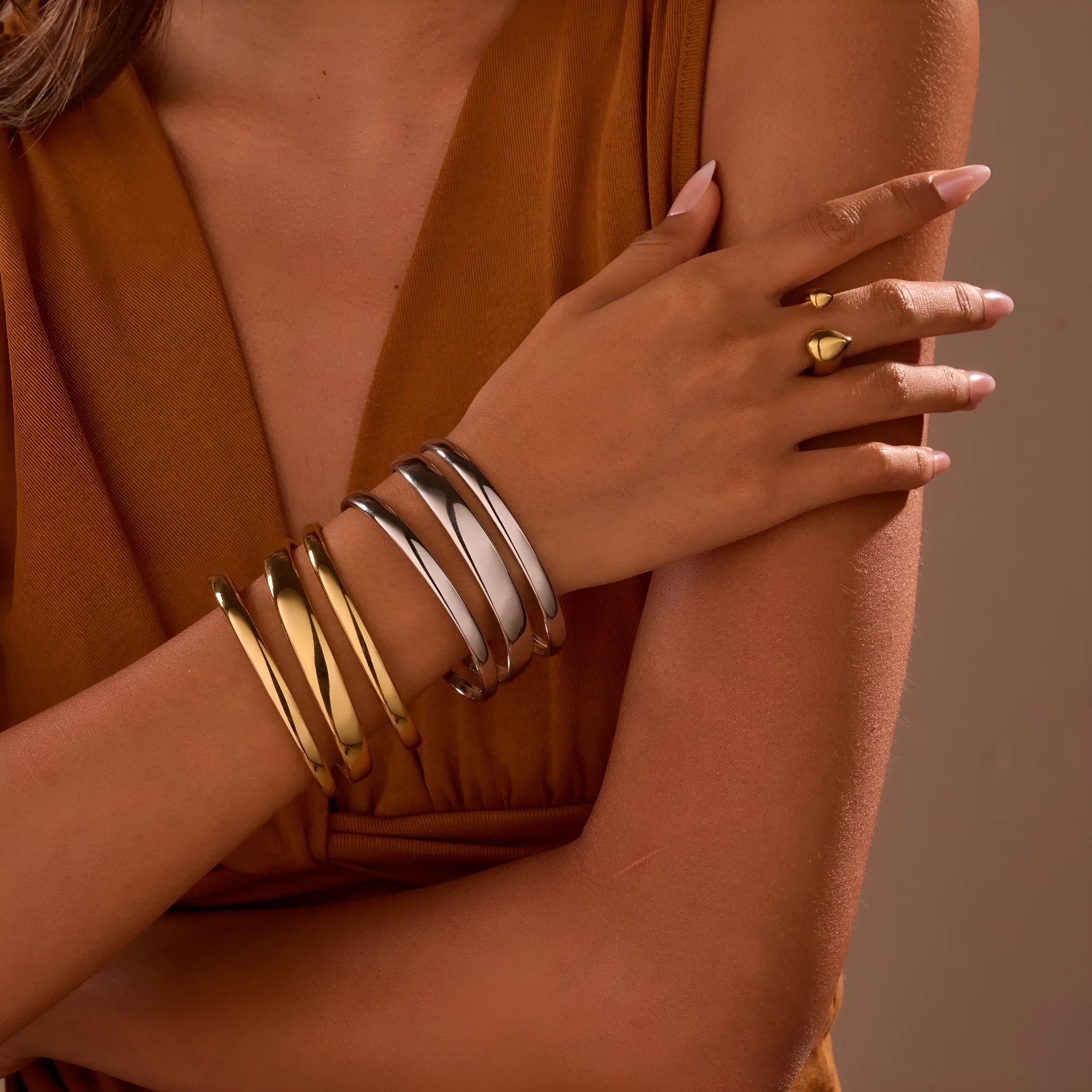 Stainless steel women's bracelet with geometric line design, shown in gold and steel finish options