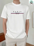 Man wearing a loose fit apricot coloured short-sleeved T-shirt with a black letter print on the front.