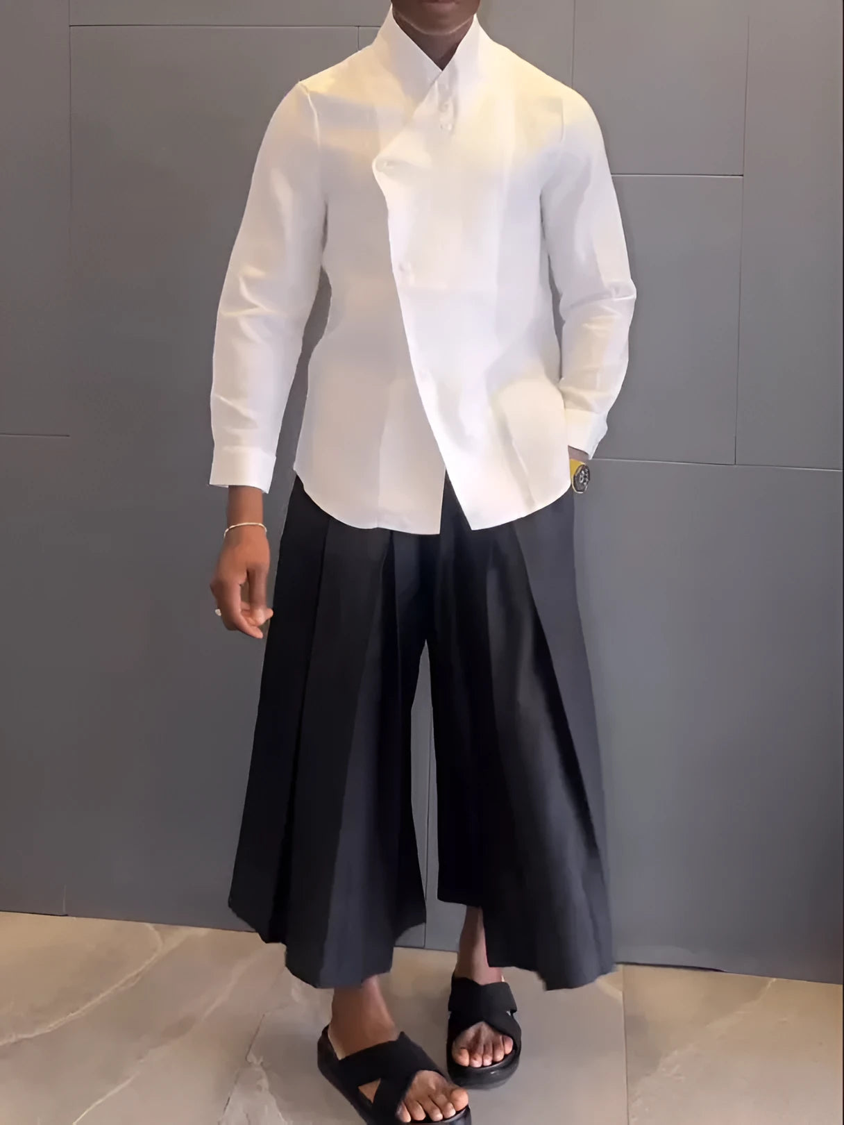 White asymmetrical front long sleeve shirt paired with black pleated trousers in a women's two-piece set.