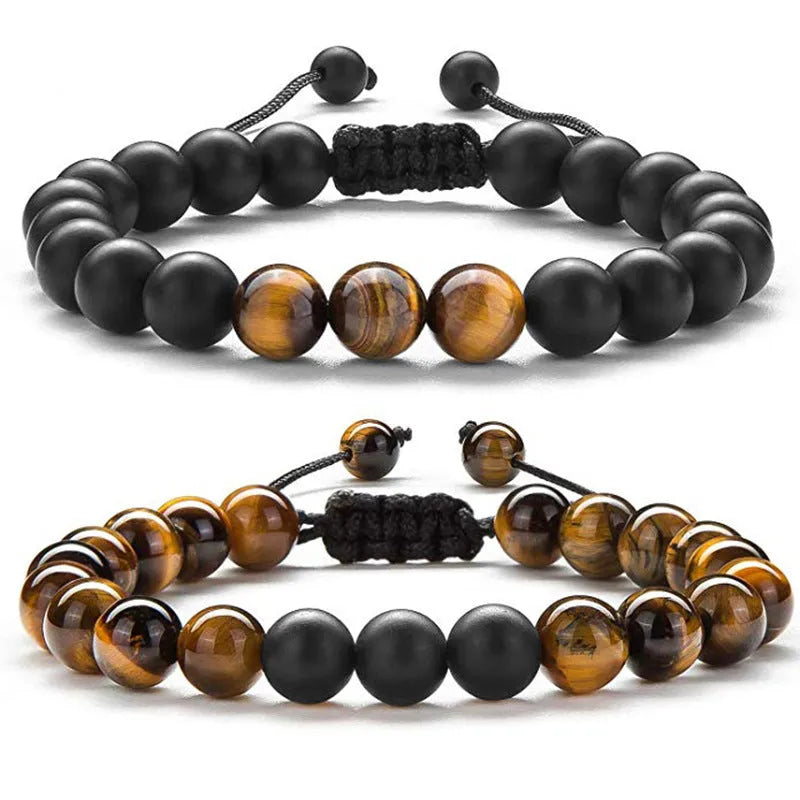 A pair of geometric matte black agate bead bracelets for couples on a neutral background.