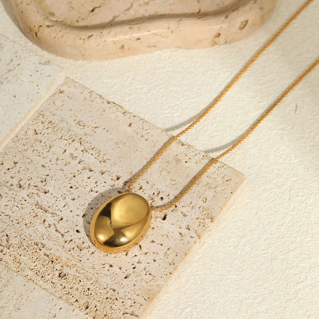Geometric gold-plated pendant necklace with adjustable chain on white background