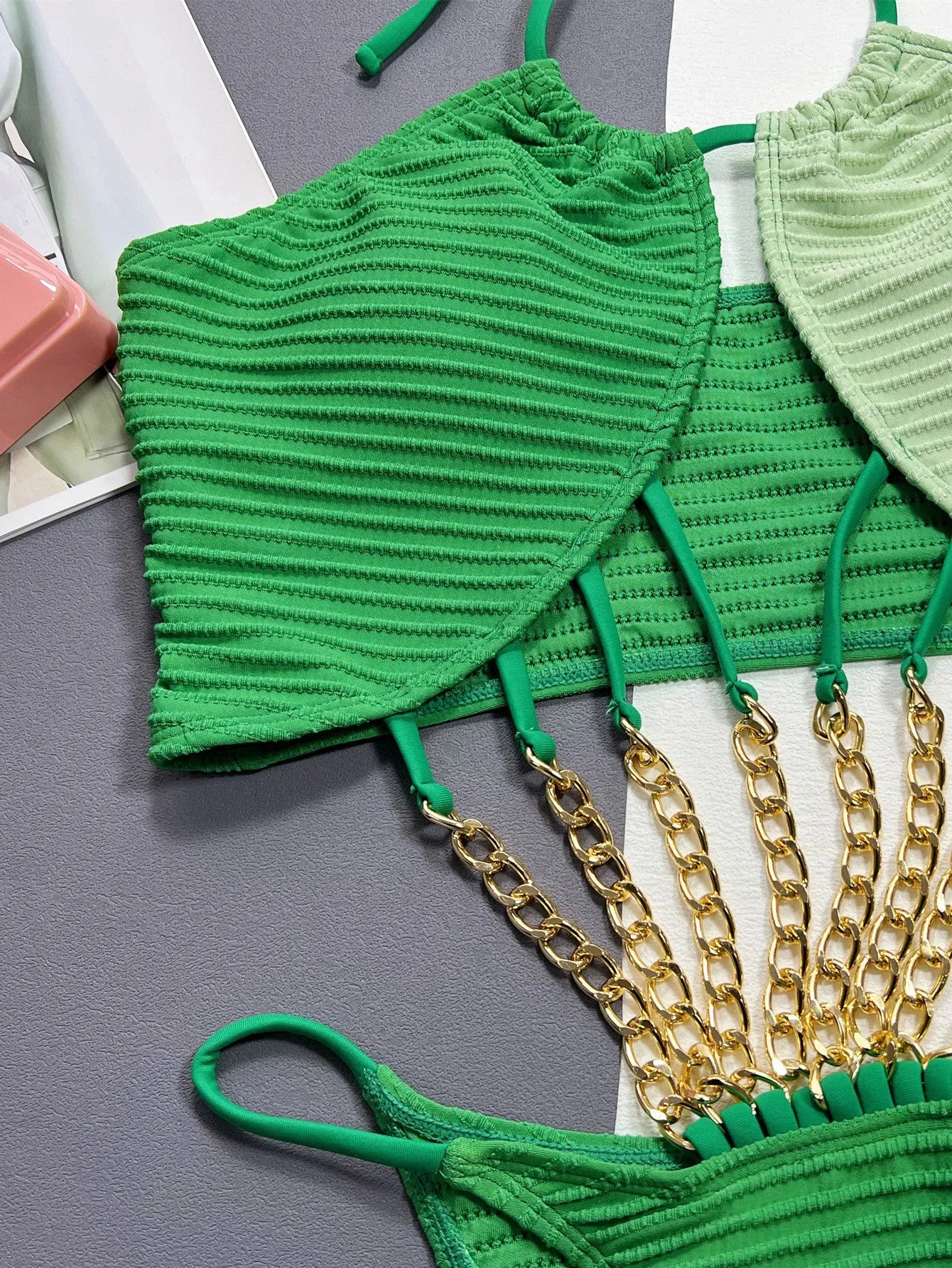 Green women's one-piece swimsuit with hollowed side panels on mannequin