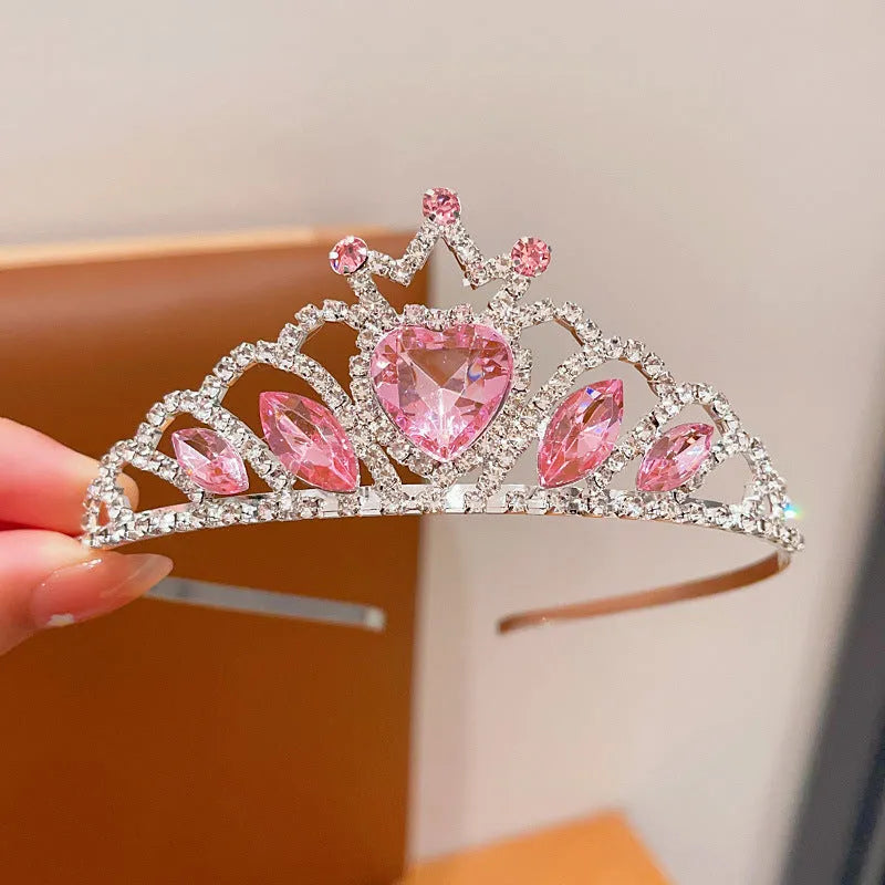 Children's electroplated alloy crown headband with pink crystals, shown on a model for scale.