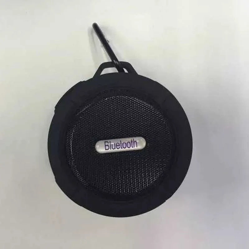 Portable waterproof Bluetooth speaker in blue with a mountaineering buckle clip for bags.