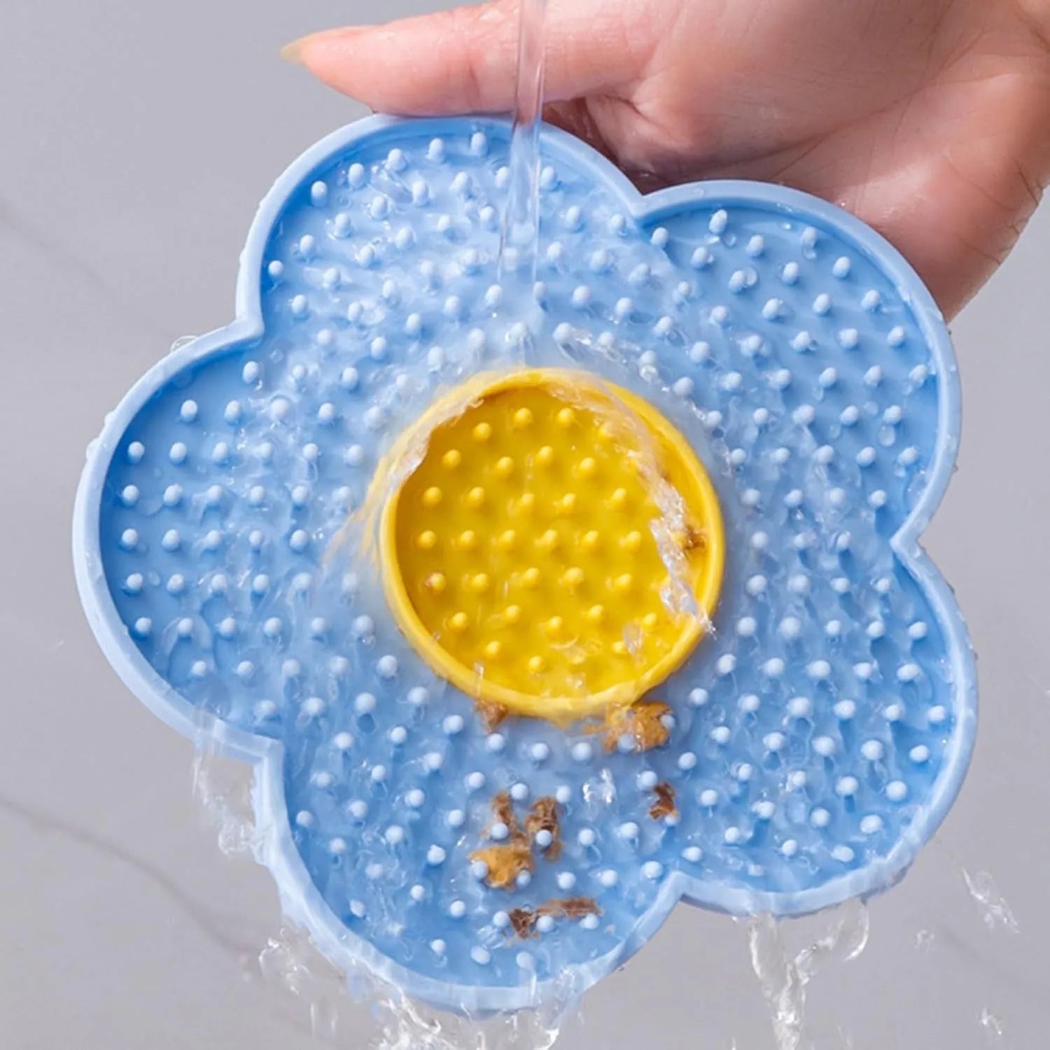 Flower-shaped silicone pet licking mat with suction cups on back in blue, grey, pink, purple, or red