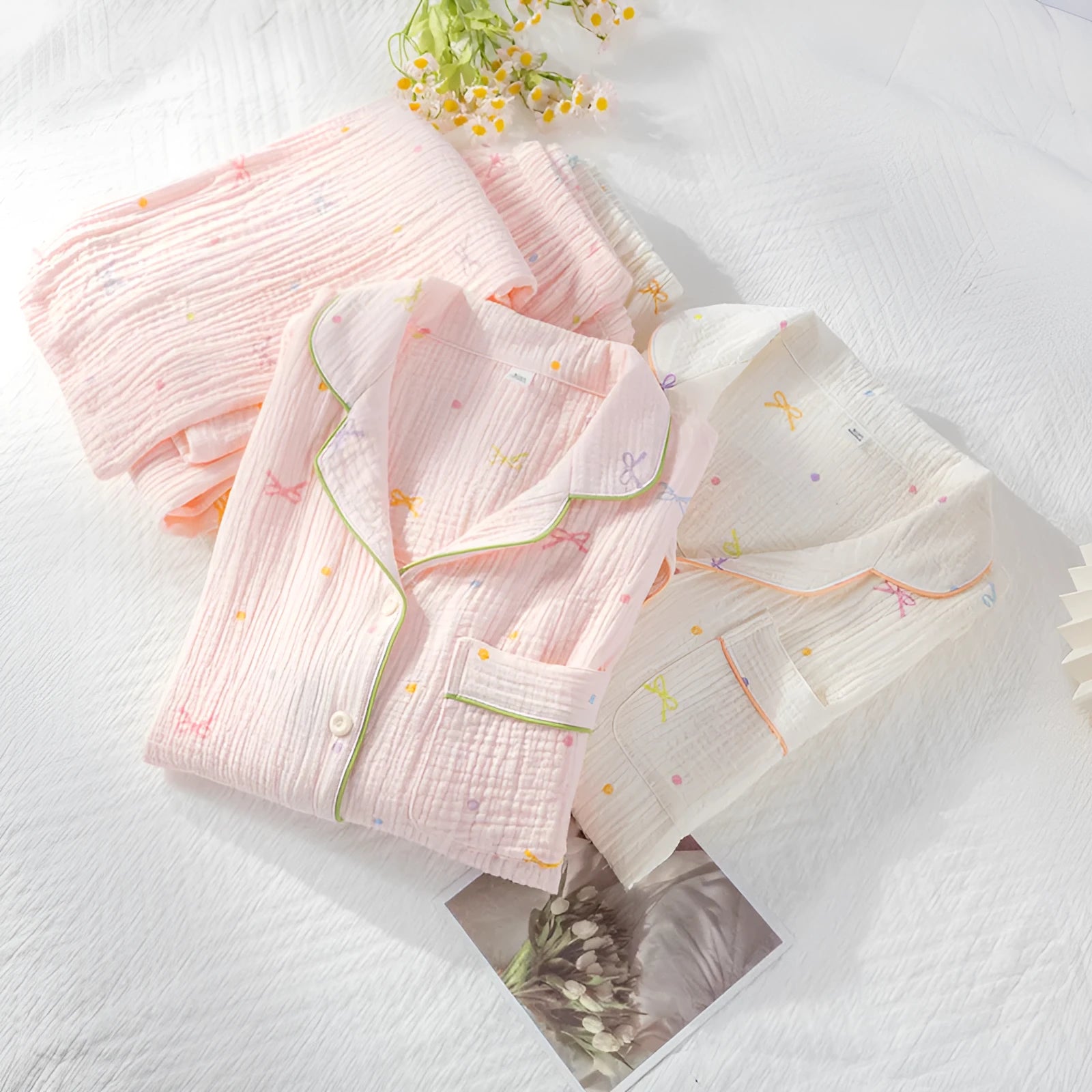 Women's pink cotton crepe pajama suit with long sleeves and trousers laid flat.