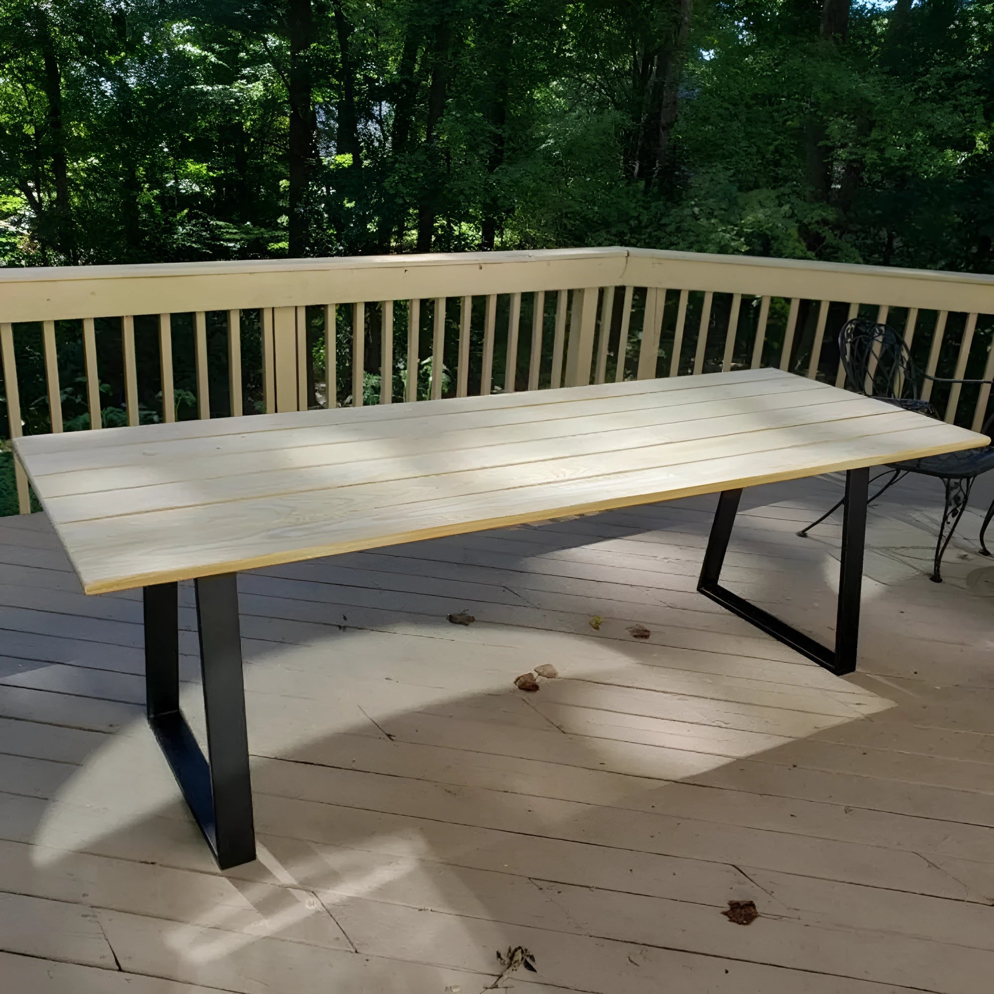 Wrought iron table legs in matte black finish with screws and foot pads on floor