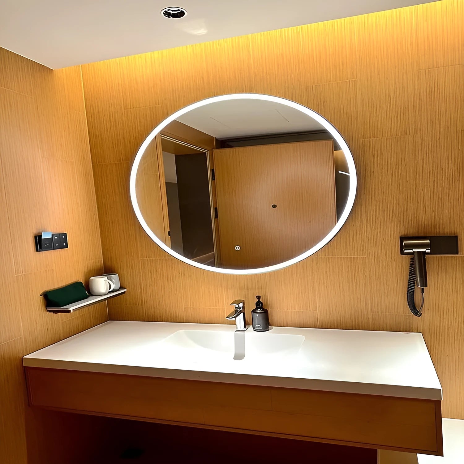 Round black aluminium frame LED bathroom mirror mounted on wall with dimmable lights on.