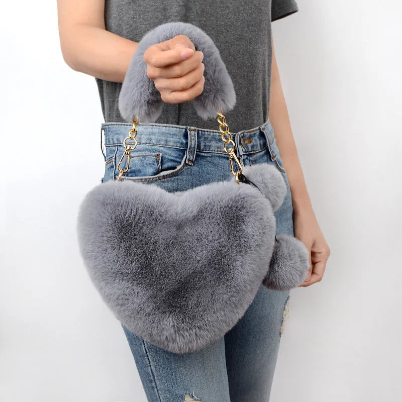 Soft plush heart-shaped women's handbag in a medium size with a removable shoulder strap.