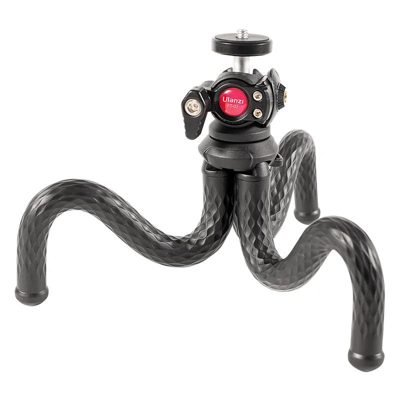 Black octopus leg mobile phone tripod with clip, extended to 360mm on a table.