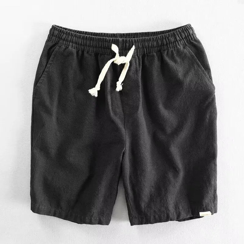 Man wearing loose-fit beige cotton linen casual shorts on a beach