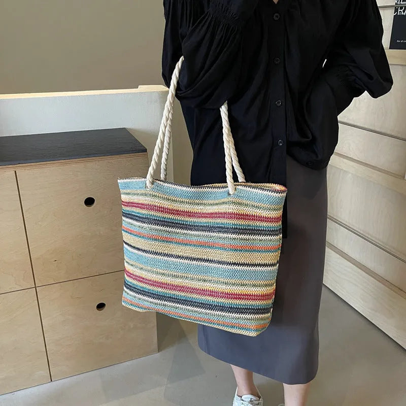 Blue woven straw and nylon shoulder bag with a single strap.
