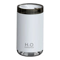 White jellyfish-shaped USB humidifier emitting smoke ring mist with warm night light glow on a table.