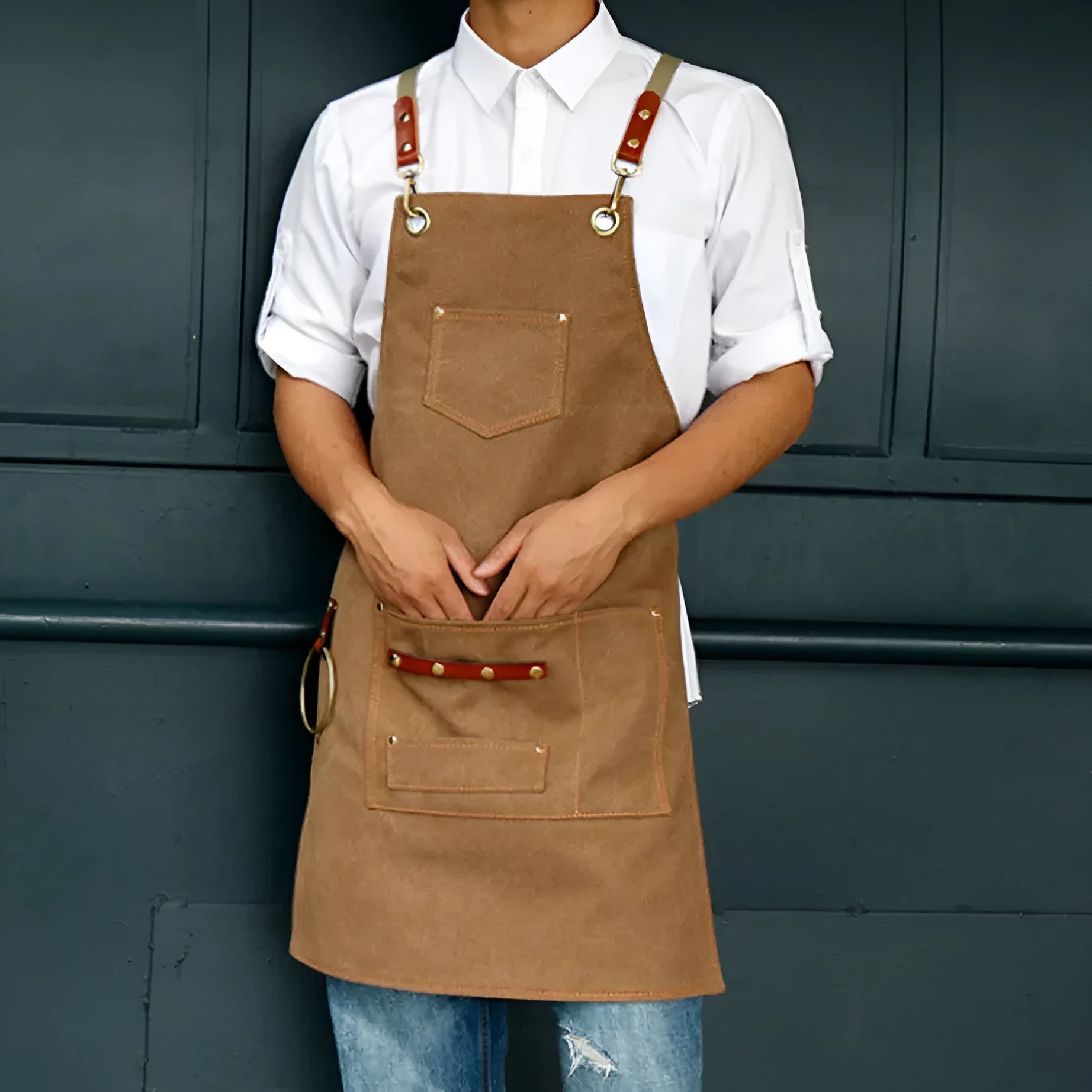Canvas apron with cross-back straps in camel colour, shown laid flat