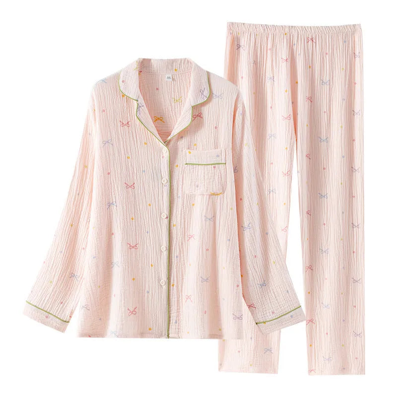 Women's pink cotton crepe pajama suit with long sleeves and trousers laid flat.
