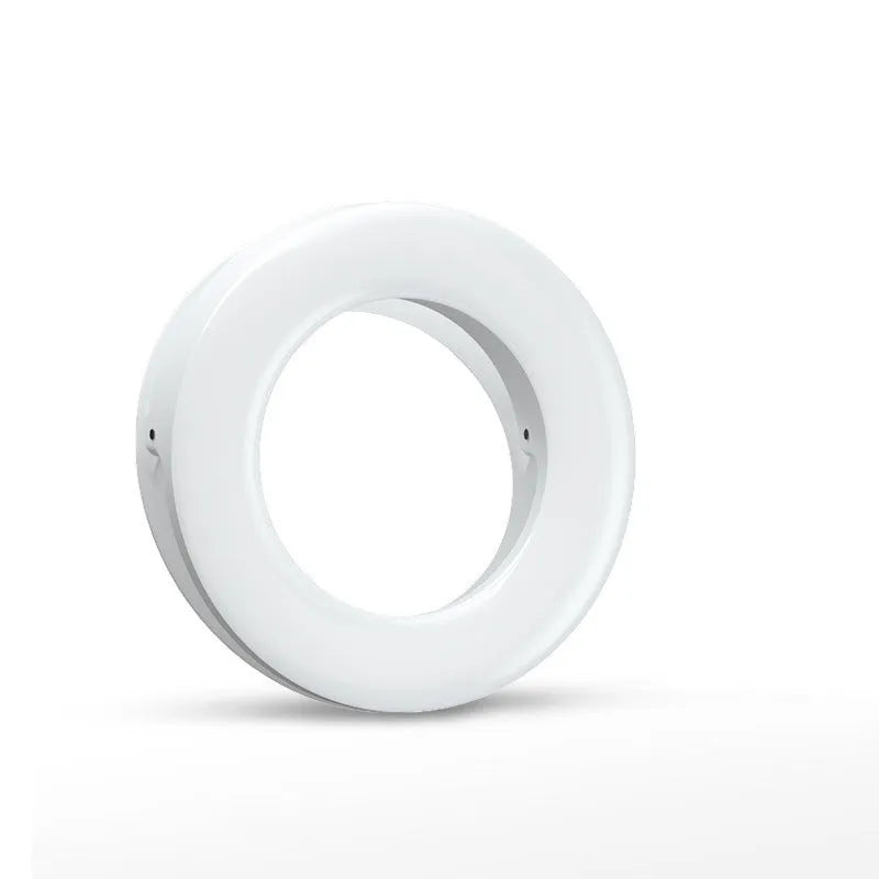 Black USB-rechargeable LED selfie ring light for mobile phone photography on a table.