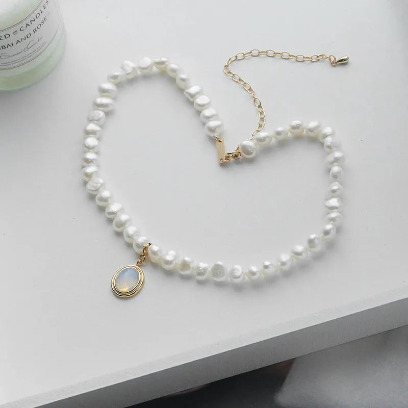 Sterling silver geometric necklace with irregular pearl pendant on adjustable chain.