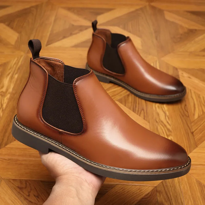 Black formal pointed-toe leather boots with a square heel and rubber sole on a neutral background.