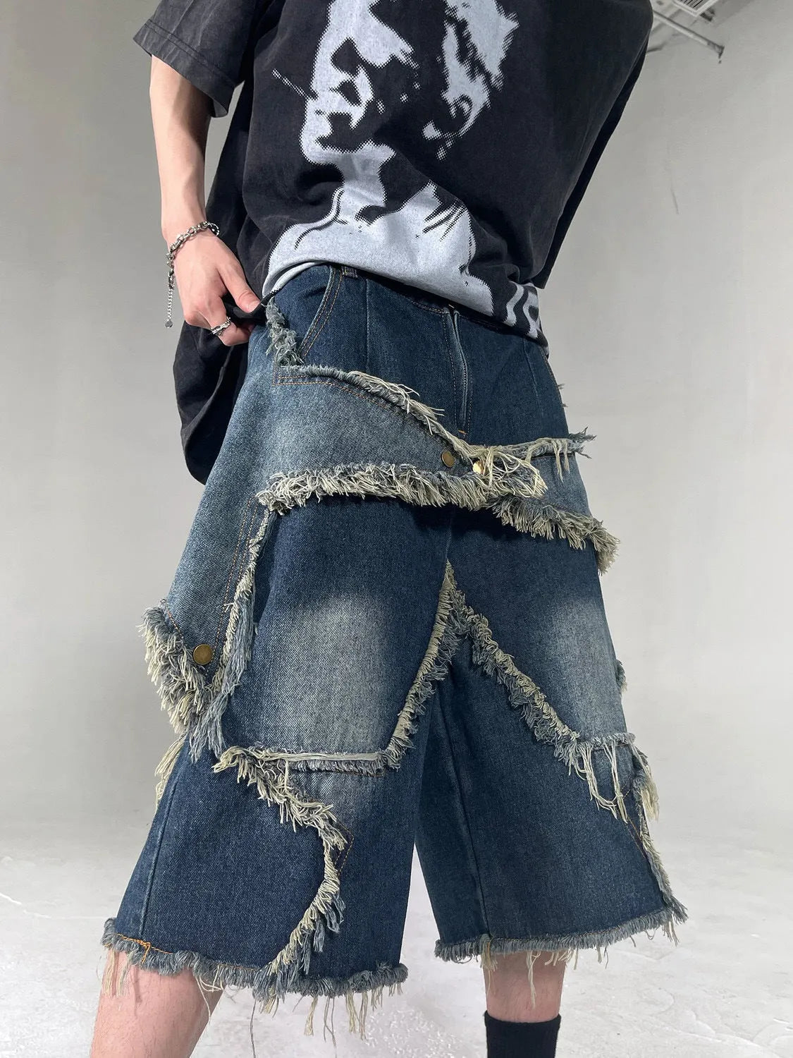 Blue denim shorts with frayed five-pointed star design in loose retro style