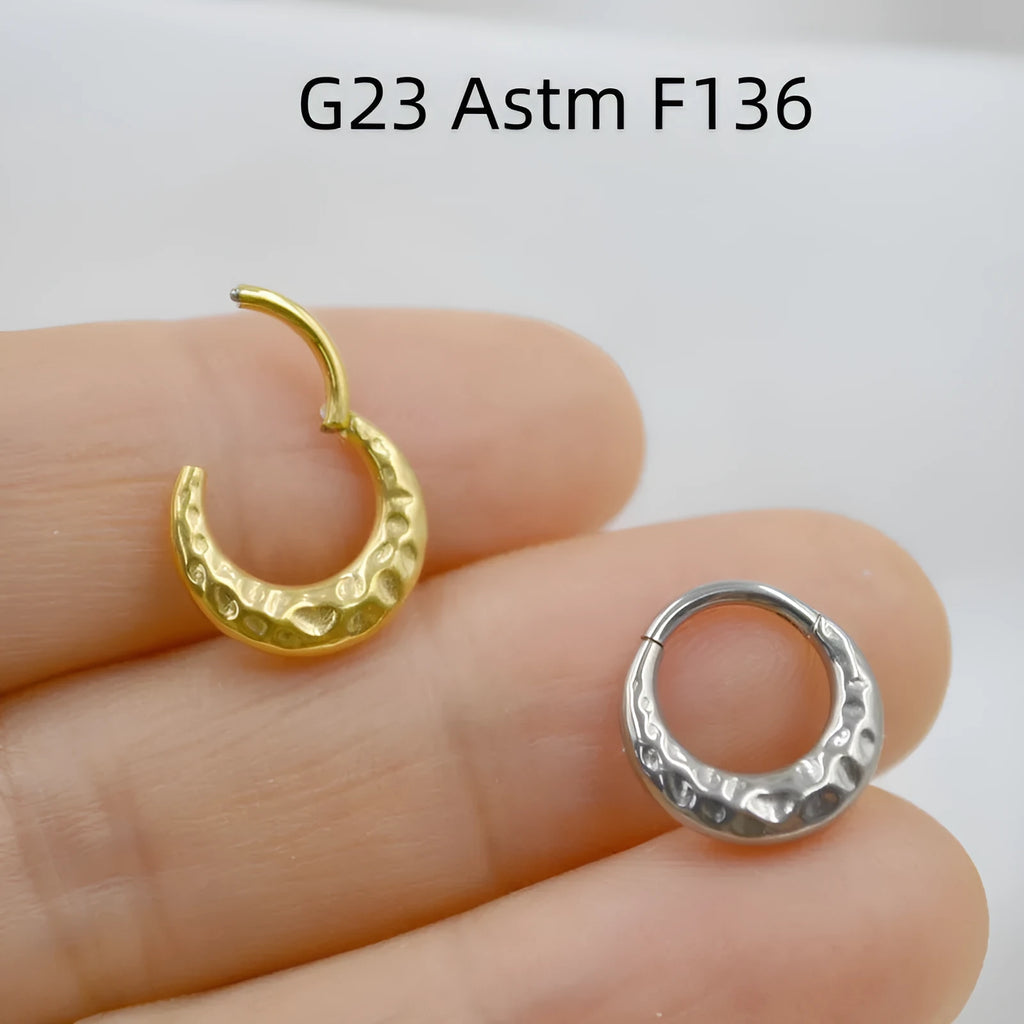 Titanium alloy concave-convex nose ring with carving detail in gold and silver anodised finishes.