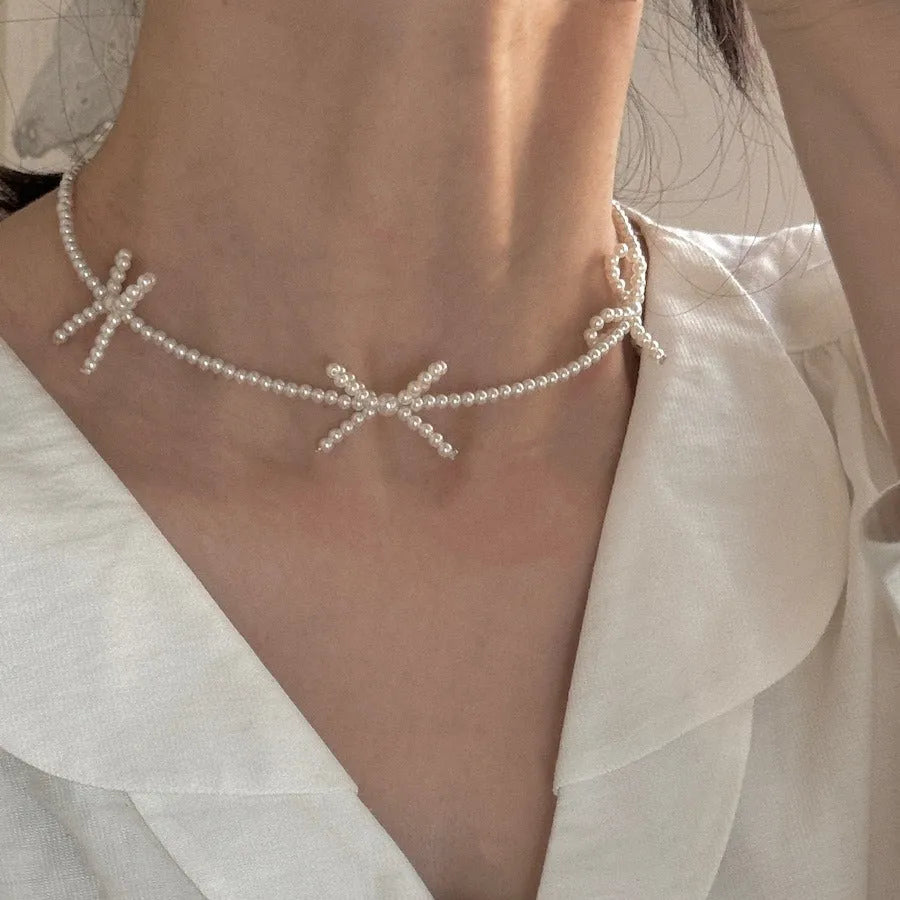 White imitation pearl necklace with geometric bow pendant on adjustable 31-40cm chain